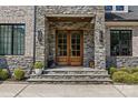 Elegant stone entryway with a wood double door and decorative lanterns at 5638 Timber Ln, Charlotte, NC 28270