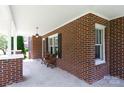 Covered porch with brick columns, seating, and a view of the landscaped front yard at 628 Stamie Dr, Chester, SC 29706