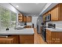 Well-lit kitchen features stainless steel appliances, wooden cabinets, and ample counter space near a bright window at 7212 Morsey Ct, Charlotte, NC 28269