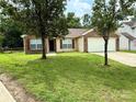 Charming brick and vinyl home with a well-maintained lawn and two-car garage at 7267 Sandown Ct, Harrisburg, NC 28075