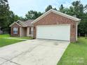Charming brick and vinyl home featuring an expansive driveway and two car garage at 7267 Sandown Ct, Harrisburg, NC 28075