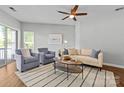 Well-lit living room with a ceiling fan, comfortable seating, and large windows offering plenty of natural light at 7845 Village Harbor Dr, Cornelius, NC 28031