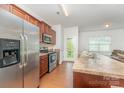 Well-lit kitchen features stainless steel appliances, wood floors, and a convenient exterior door at 8953 Bradstreet Commons Way, Charlotte, NC 28215