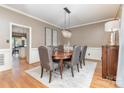 Formal dining room features a chandelier, hardwood floors, and a neutral color palette at 905 Mangionne Dr, Matthews, NC 28105
