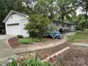 Landscaped backyard with a patio, flowers, and a garage at 103 Boyd Dr, Stanley, NC 28164