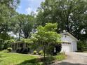 Side view of a home featuring an attached garage and a meticulously maintained front yard at 103 Boyd Dr, Stanley, NC 28164