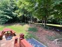 Spacious backyard with a picnic table and a terraced planting area under a canopy of trees at 1031 Daniel Dr, Stanley, NC 28164