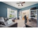 Comfortable home office featuring a cozy couch, ample natural light, and a ceiling fan at 1311 Rowan Ln, Monroe, NC 28110