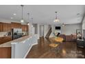 Open-concept living space featuring hardwood floors, a granite kitchen counter, and seamless connection to the living room at 1349 Bridgeford Nw Dr, Huntersville, NC 28078