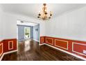 Elegant dining room with hardwood floors, wainscoting, and a chandelier, perfect for formal gatherings at 14402 Raynham Dr, Charlotte, NC 28262
