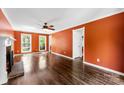 Spacious living room with hardwood floors, a brick fireplace, and ample natural light from large windows at 14402 Raynham Dr, Charlotte, NC 28262
