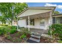 Inviting covered front porch with classic trim, wood stairs, and surrounding landscaping at 1532 Buffalo Shoals Rd, Claremont, NC 28610