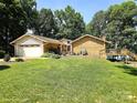 Inviting two-story brick and vinyl home with lush lawn, mature trees, and a lakeside deck at 160 Quail Hollow Dr, Kings Mountain, NC 28086