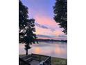 Picturesque lake view with a colorful sunset sky and a cozy seating area overlooking the water at 160 Quail Hollow Dr, Kings Mountain, NC 28086