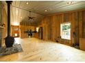 Open-concept living room with wood paneling, fireplace, and modern kitchen appliances, offering a rustic feel at 1640 Bear Poplar Rd, Cleveland, NC 27013