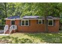 A cozy, single-story brick house with neat landscaping, complemented by blue shutters and a welcoming entrance at 1709 Masonic Dr, Charlotte, NC 28205