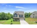 Charming two-story home featuring a stone facade, blue accents, and a well-manicured front yard at 2009 Trindle Vine Ln, Waxhaw, NC 28173