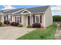 Inviting brick townhome with a concrete driveway and lush lawn, enhanced by stylish shutters at 2045 Pin Oak Pl, Cramerton, NC 28032