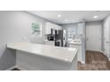 Well-lit kitchen with white cabinets, modern appliances, and a convenient breakfast bar area at 2045 Pin Oak Pl, Cramerton, NC 28032
