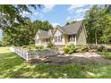 Bright home showcasing well-maintained landscaping and a quaint white picket fence at 2159 Quiet Cove Ln, Stanfield, NC 28163