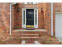 Close-up of the elegant front door with brick surround, enhancing the home's curb appeal at 2321 Oberwood Dr, Charlotte, NC 28270