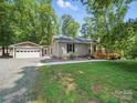 Charming single story home featuring a detached garage, gravel driveway, and a welcoming wooden deck at 2345 Stallings Rd, Matthews, NC 28104