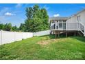 Spacious backyard featuring a white fence, a well-maintained lawn, and a deck with white railings at 2467 Hawk Ridge Dr, Gastonia, NC 28056
