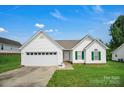 Inviting single-story home with a well-kept lawn, white siding, green shutters, and a two-car garage at 2467 Hawk Ridge Dr, Gastonia, NC 28056