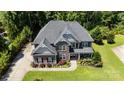 Stunning aerial view of a two-story home featuring lush landscaping, and a beautiful gray roof at 3963 Harmattan Dr, Denver, NC 28037