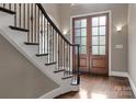 Bright foyer featuring a staircase with iron railings and a glass paneled double door at 4218 Ash Hollow Ln, Denver, NC 28037
