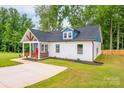 Well-manicured lawn surrounds a delightful cottage-style home with white siding at 516 North Mulberry St, Cherryville, NC 28021