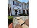 Inviting front entrance of a well-maintained townhouse with a small garden area at 5650 Kimmerly Woods Dr, Charlotte, NC 28215