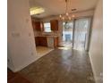 Eat-in kitchen featuring oak cabinets, white appliances, and a chandelier over the dining area at 5650 Kimmerly Woods Dr, Charlotte, NC 28215