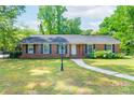 Lovely brick home featuring a manicured lawn, decorative lamp post, and a sidewalk leading to the front entrance at 5720 Amity Pl, Charlotte, NC 28212