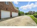 The long concrete driveway leads to the attached two-car garage and lush backyard at 5916 Four Wood Dr, Matthews, NC 28104