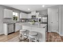 Bright kitchen with white cabinets, granite countertops, stainless steel appliances, and a cozy breakfast bar at 5995 Granbury Dr, Kannapolis, NC 28081