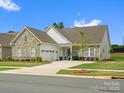 Beautiful single-story home with stone and siding exterior, lovely landscaping, and an attached garage at 6020 Waldorf Ave, Monroe, NC 28110