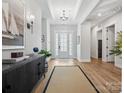 Bright foyer with hardwood floors, tray ceiling, decorative lighting, and a view of the front door at 6020 Waldorf Ave, Monroe, NC 28110