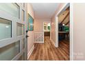 Inviting foyer featuring wood floors, a modern front door, and an open view into the kitchen at 617 Pinecrest St, Davidson, NC 28036