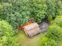 Aerial view of a two-story home featuring a private setting, mature landscaping, and roof at 676 Cottingham Ne Pl, Concord, NC 28025
