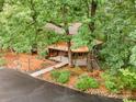 Aerial view of charming two-story home with mature landscaping, walkway, and deck at 676 Cottingham Ne Pl, Concord, NC 28025