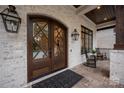 Inviting front entrance with double doors, complemented by outdoor seating and stylish exterior lighting at 8170 Bay Pointe Dr, Denver, NC 28037