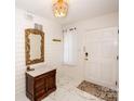 Bright foyer featuring an ornate mirror, wooden accent furniture, stylish lighting fixture, and marble-patterned floors at 899 Wendover Rd # 29, Statesville, NC 28677