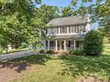 Beautiful two-story home with a classic front porch, well-maintained lawn, and mature trees at 9422 Olivia Ln, Charlotte, NC 28277