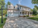 Traditional two-story home with a spacious driveway, two-car garage, and inviting front porch at 9422 Olivia Ln, Charlotte, NC 28277