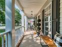 Inviting front porch with rocking chairs, accent plants, and stylish lighting fixtures at 9422 Olivia Ln, Charlotte, NC 28277