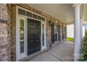 Inviting front porch featuring a black front door with white trim, and brick facade at 9937 Violet Cannon Nw Dr, Concord, NC 28027