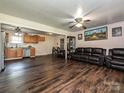 Inviting living room featuring dark wood flooring, a leather sofa, and seamless transition to the kitchen at 12423 Softwood Ct, Charlotte, NC 28273