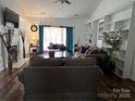 Cozy living room with a fireplace, large windows, and built-in bookshelves at 13409 Planters Row Dr, Charlotte, NC 28278