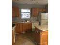 Efficient kitchen with wooden cabinets, a double basin sink, and essential appliances at 136 Mangum Cir, Mooresville, NC 28117